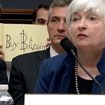 Buy Bitcoin sign behind Janet Yellen's back mug